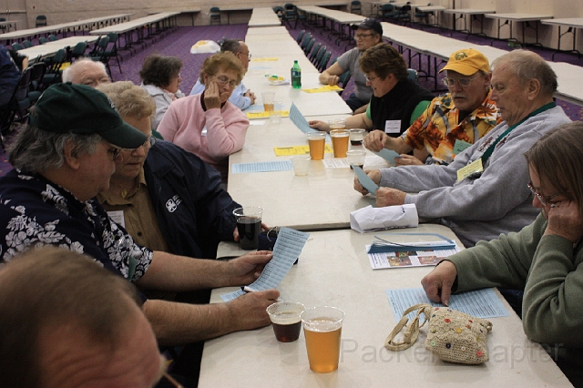 2009TAT_ 456.jpg - Early arrivers for the night time raffle check over the prize listing.